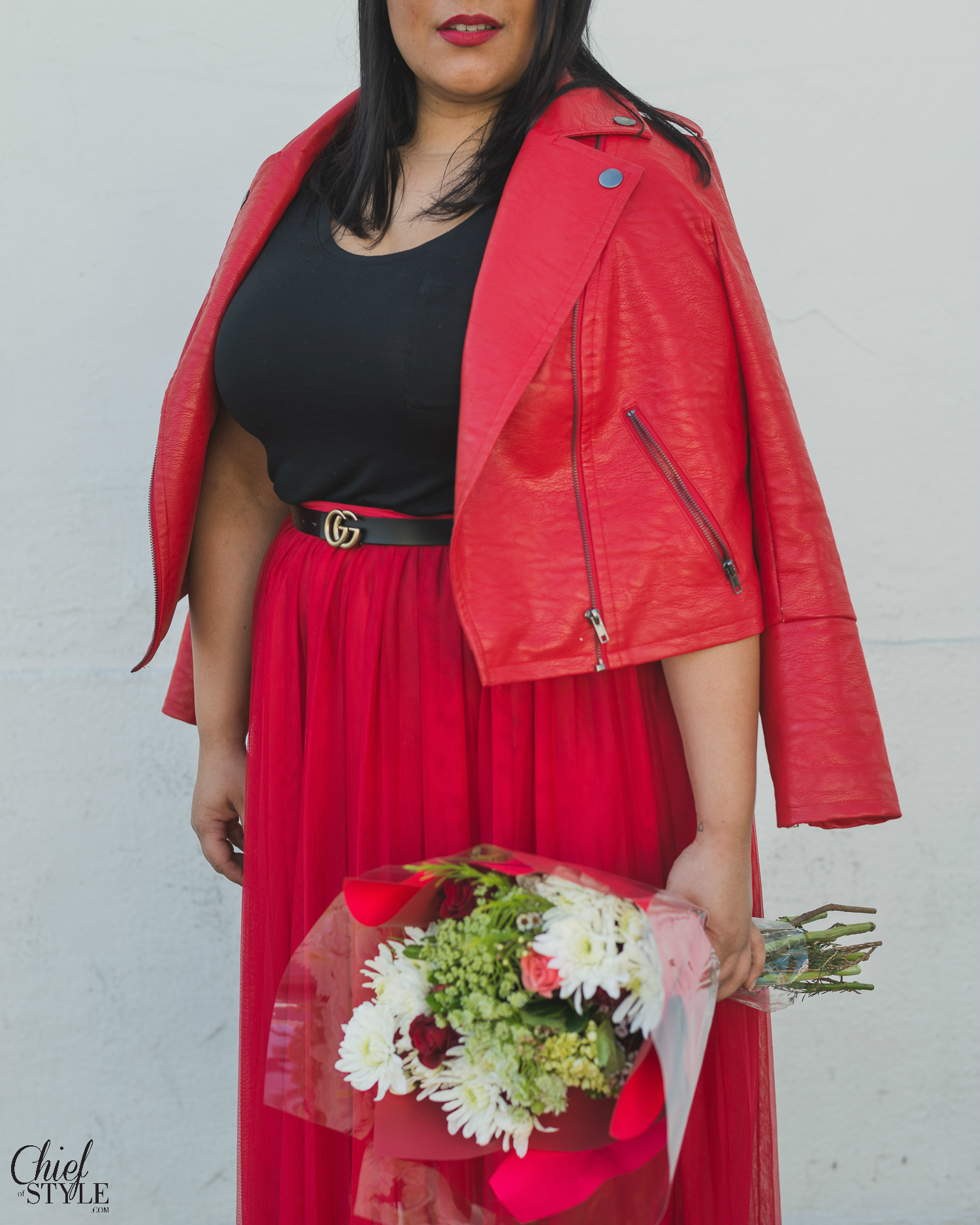 Amy Stretten Chief of Style at a pizza parlor in Hollywood, California wearing a red eloquii moto jacket and a red eloquii tuelle skirt